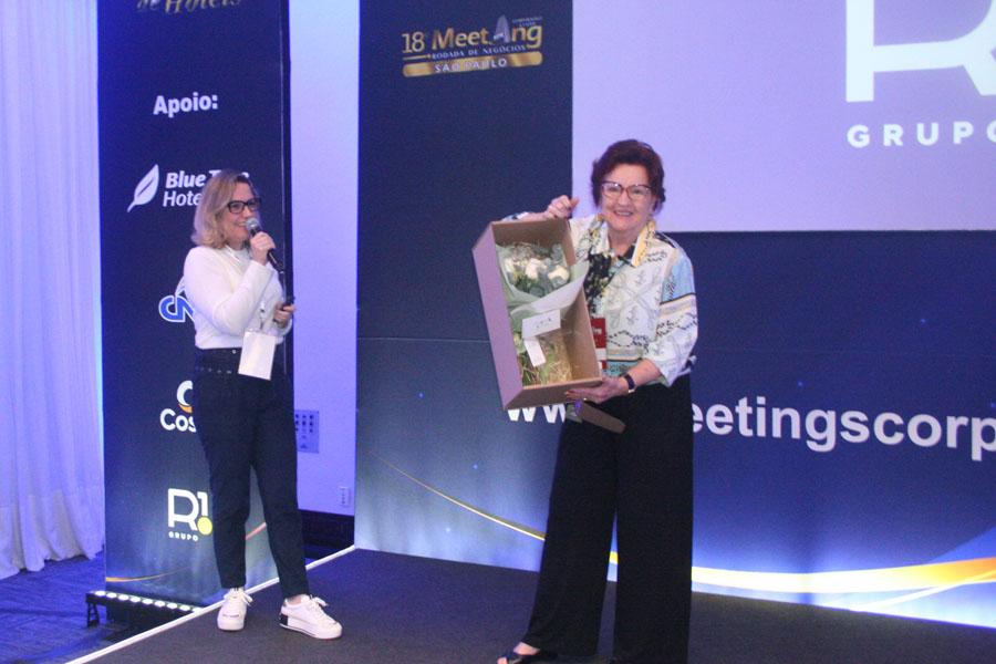 Elza Wolcoff, foi agraciada com um buquet de rosas brancas, entregues por Andreia Chiarato, da R1.